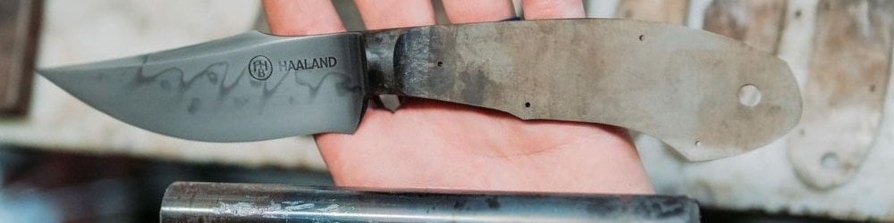 Freshly forged blade and steel rod in smiths hand