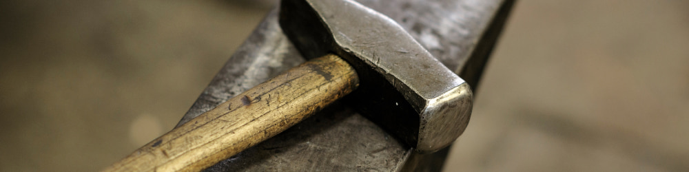 Blacksmithing hammer resting on anvil