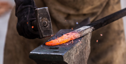 Bladcksmith forging a blade on an anvil