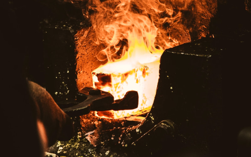 Piece of red hot glowing metal in forge