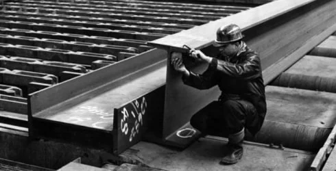 Old photo of construction workers working with steel beams
